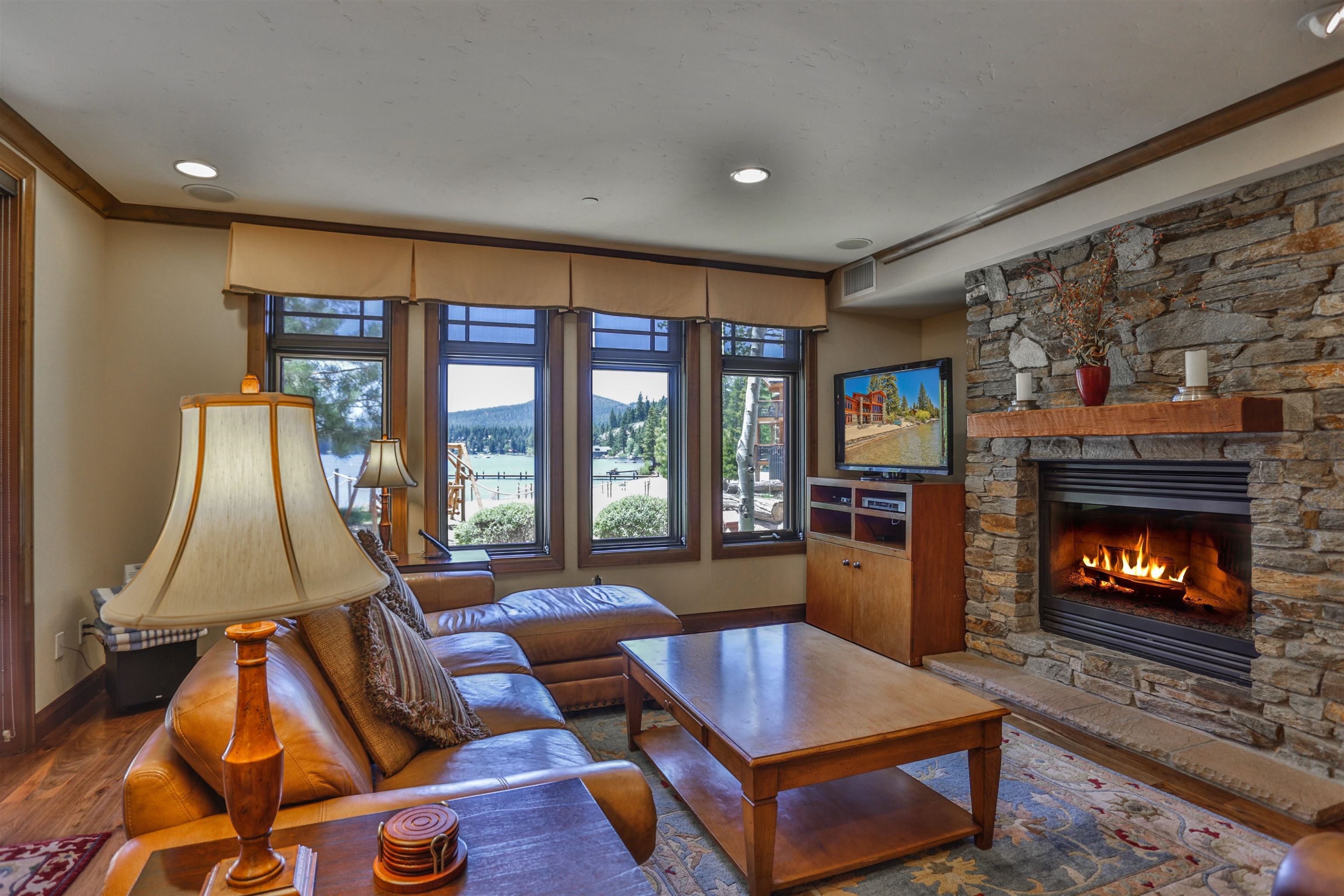 6750 North Lake Boulevard, Unit 3C Tahoe Vista, CA 96148 - Photo 15 of 22 a living room with furniture a fireplace and a floor to ceiling window