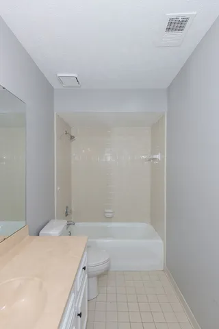 a bathroom with a granite countertop sink a toilet and shower