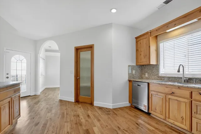 a kitchen with granite countertop a sink cabinets and wooden floor