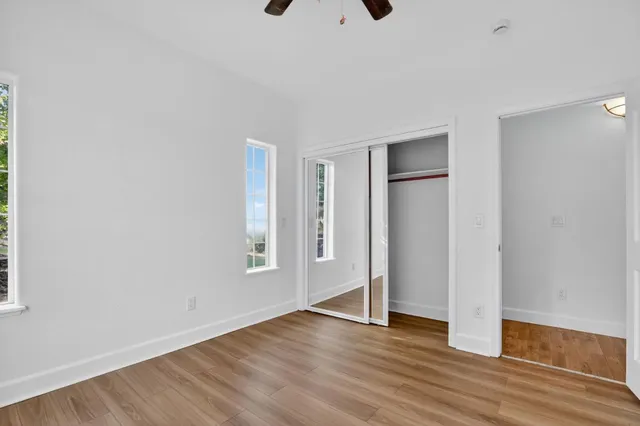 an empty room with wooden floor and windows