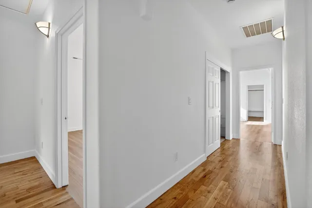 a view of a hallway with wooden floor