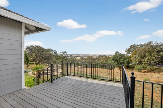 a view of a balcony with wooden floor and fence