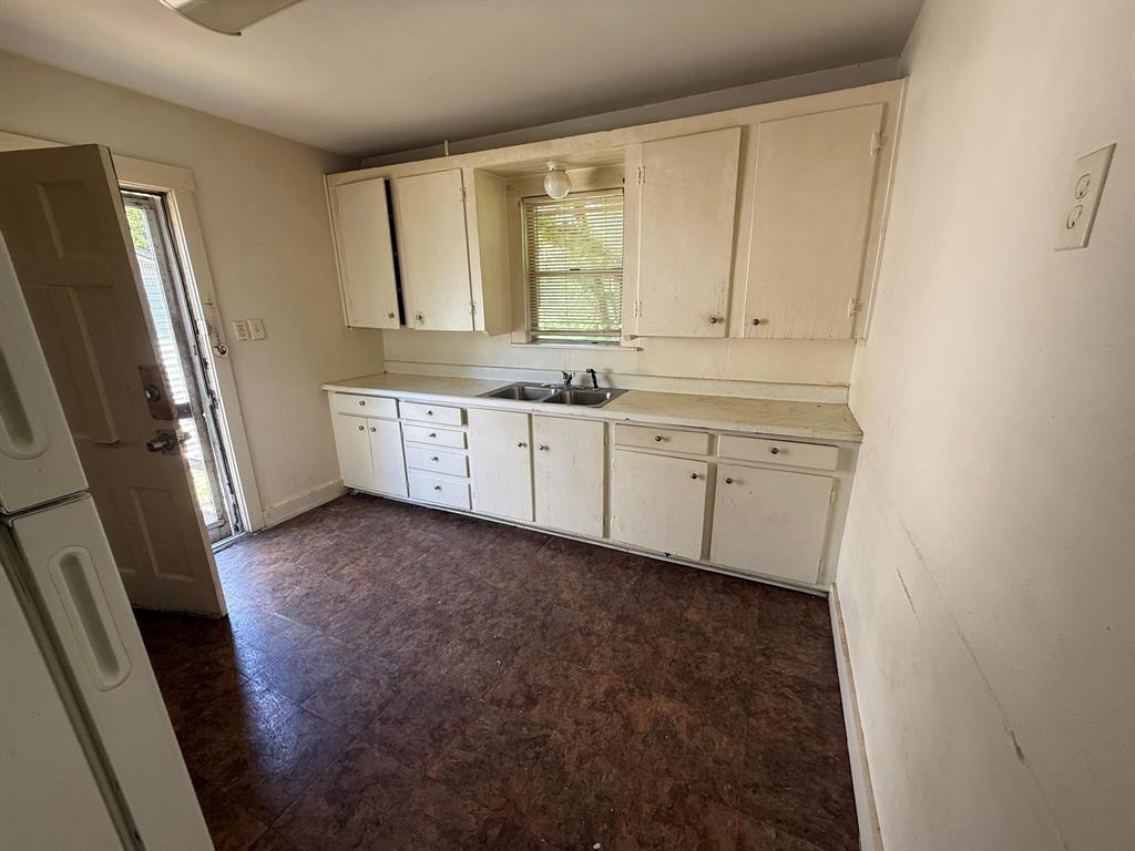 1724 McFerrin Avenue Waco, TX 76708 - Photo 4 of 11 a room with granite countertop a sink a window and a refrigerator