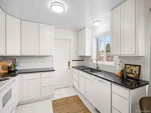 a kitchen with granite countertop a sink a stove and cabinets