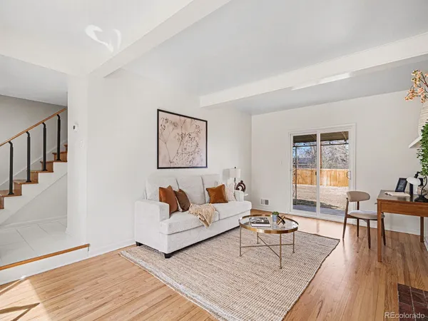 a living room with furniture and a wooden floor