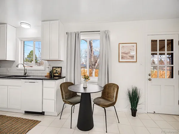 a kitchen with stainless steel appliances a dining table chairs and a refrigerator