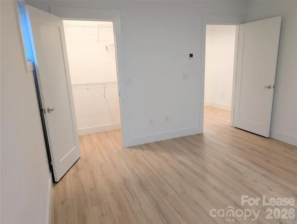 an empty room with wooden floor and entrance