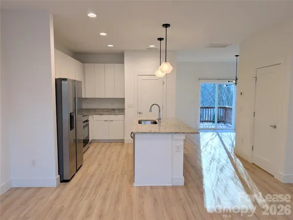 a kitchen with kitchen island a counter top space a sink stainless steel appliances and cabinets