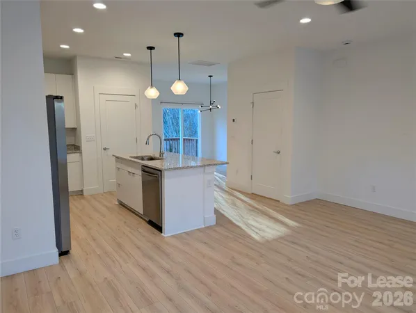 an open kitchen with a refrigerator and microwave