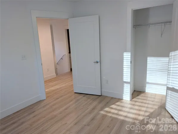 a view of a room with wooden floor and a bathroom