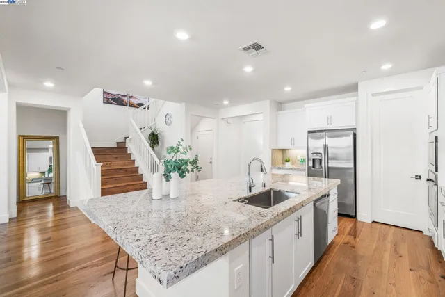 a kitchen with granite countertop a sink a counter top space and cabinets