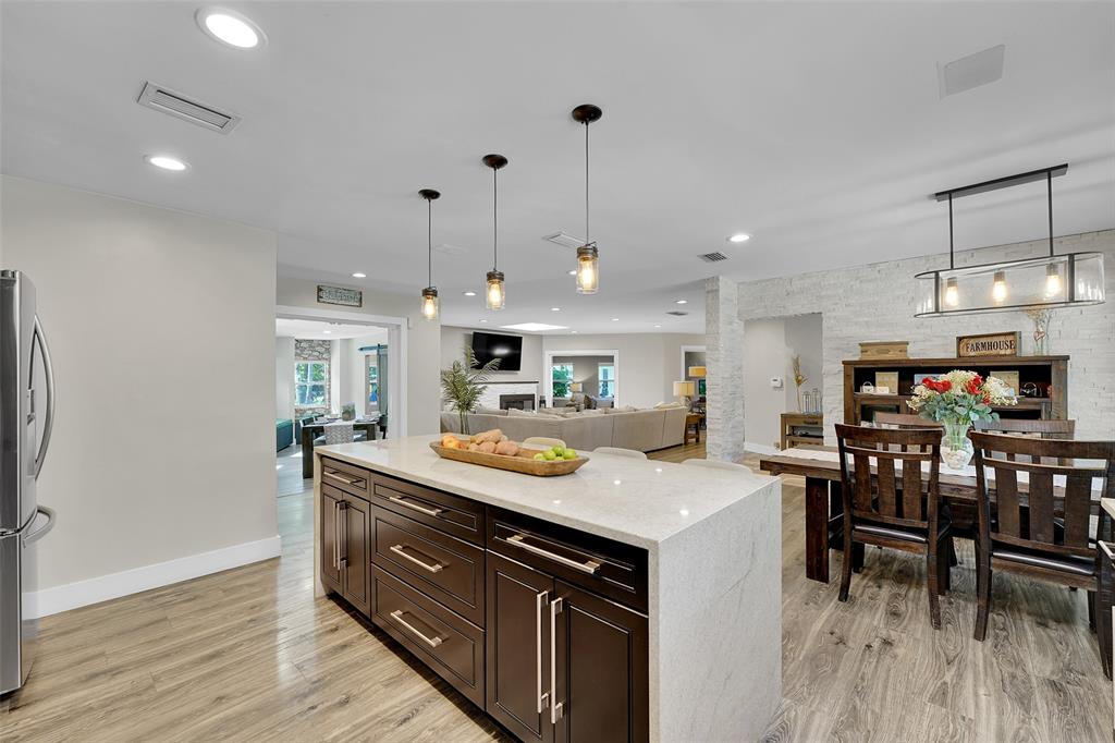 5351 Godfrey Road Parkland, FL 33067 - Photo 22 of 100 a kitchen with a stove a refrigerator and a dining table with wooden floor