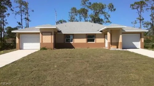 a front view of a house with a yard and garage