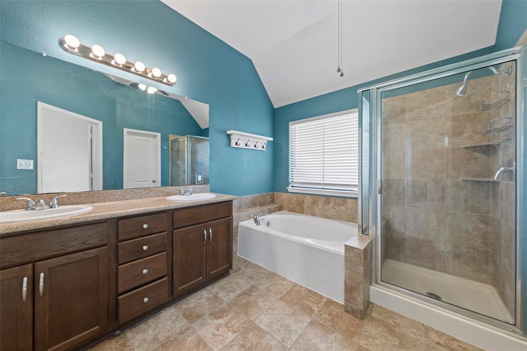 10445 Condor Loop Waco, TX 76708 - Photo 11 of 22 a bathroom with a tub a double vanity sink and a mirror
