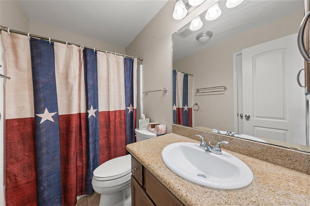 10445 Condor Loop Waco, TX 76708 - Photo 15 of 22 a bathroom with a granite countertop toilet sink and mirror