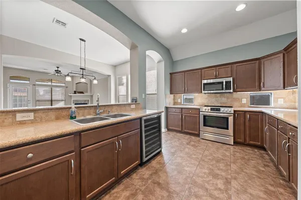 a kitchen with kitchen island granite countertop a sink stainless steel appliances and cabinets