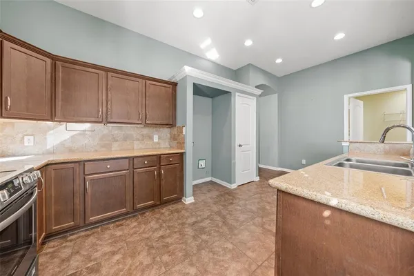 a kitchen with granite countertop a sink stainless steel appliances and cabinets