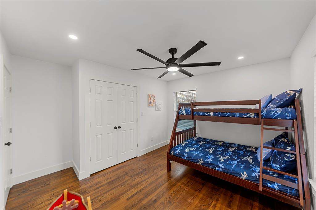 2945 Healey Drive Dallas, TX 75228 - Photo 23 of 38 a bedroom with a bed and a chandelier