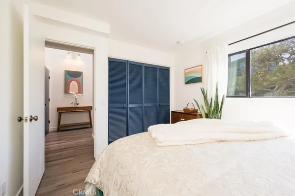 a bedroom with a bed and a painting on the wall