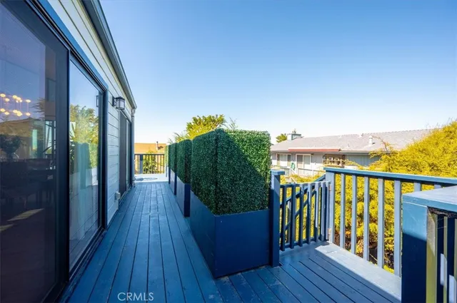 a backyard of a house with plants and large trees with wooden fence