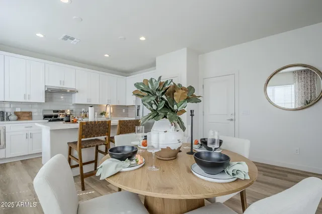 a kitchen with a sink white cabinets and wooden floor