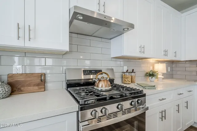 a kitchen with stainless steel appliances granite countertop a sink a stove and refrigerator
