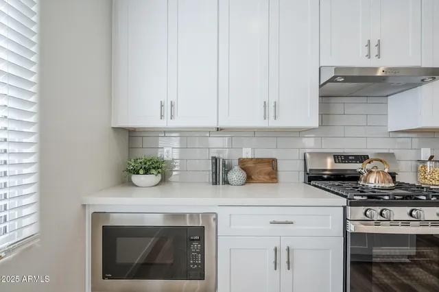 a kitchen with stainless steel appliances a sink stove and cabinets