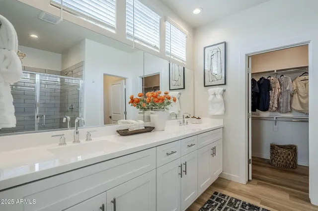 a bathroom with a double vanity sink a toilet and a shower