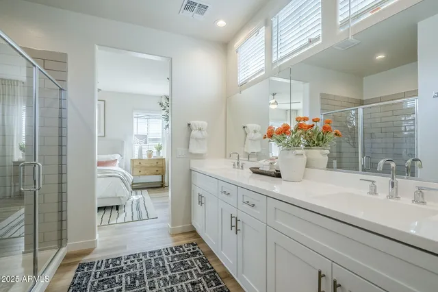 a view of a white house with a large window and flower plants