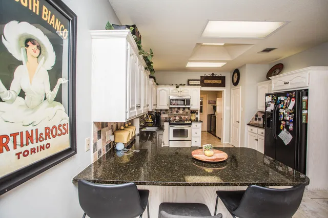 a kitchen that has a lot of cabinets a sink and appliances in it