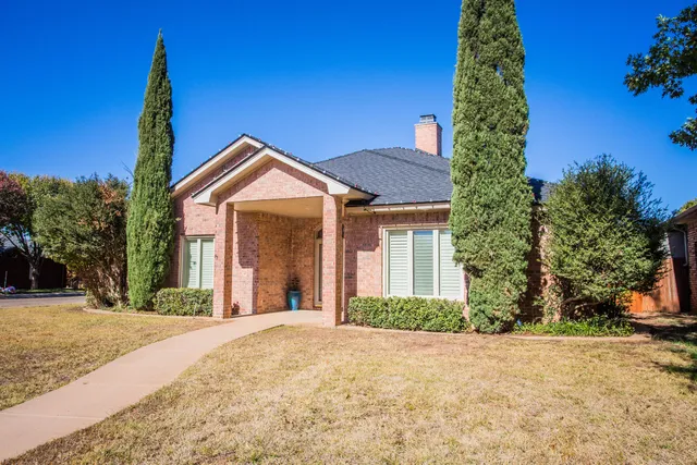 a front view of a house with a yard and potted plants