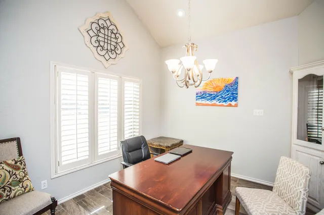a view of a workspace with furniture and a window