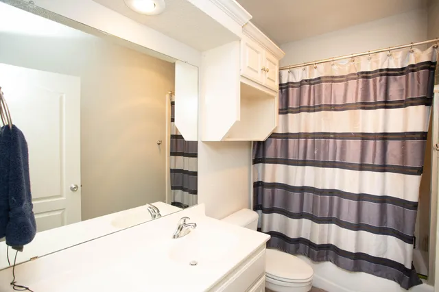 a bedroom with a bed and a ceiling fan