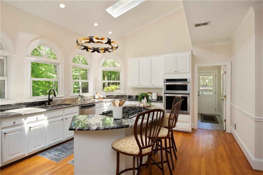 2935 Coles Way Atlanta, GA 30350 - Photo 18 of 56 a kitchen with stainless steel appliances granite countertop a stove top oven a sink a dining table and chairs