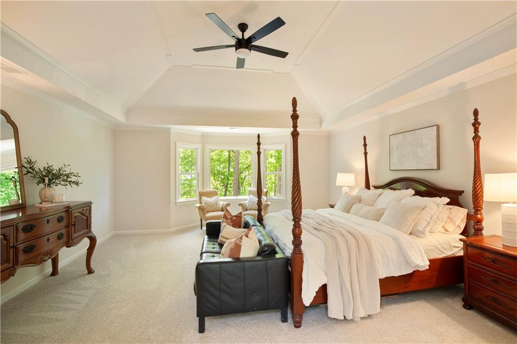 2935 Coles Way Atlanta, GA 30350 - Photo 24 of 56 a spacious bedroom with a bed a couch and a chandelier