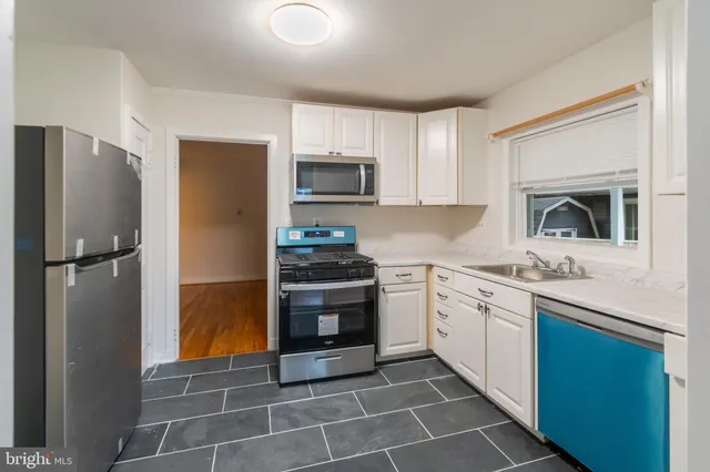 a kitchen with stainless steel appliances granite countertop a refrigerator sink and stove