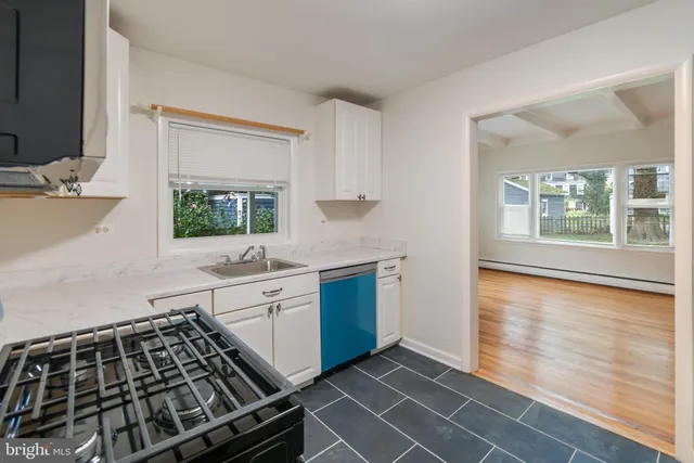 a kitchen with a stove a sink and a window