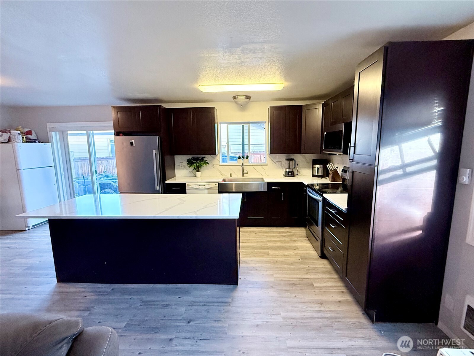 812 Ferry Street Wenatchee, WA 98801 - Photo 21 of 29 a kitchen with stainless steel appliances a sink a stove a refrigerator cabinets and a center island