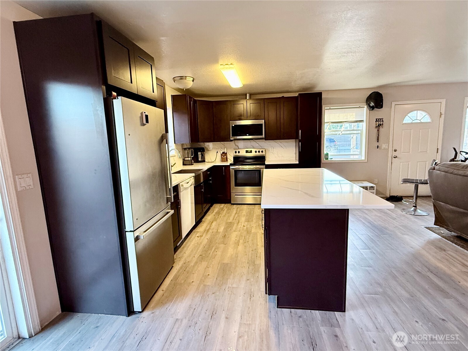 812 Ferry Street Wenatchee, WA 98801 - Photo 25 of 29 a large kitchen with stainless steel appliances a refrigerator a sink dishwasher a stove and white countertops with wooden floor