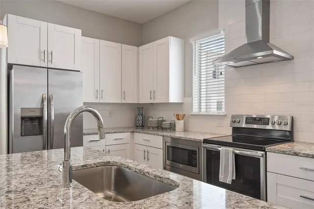 a kitchen with stainless steel appliances granite countertop a sink stove and refrigerator