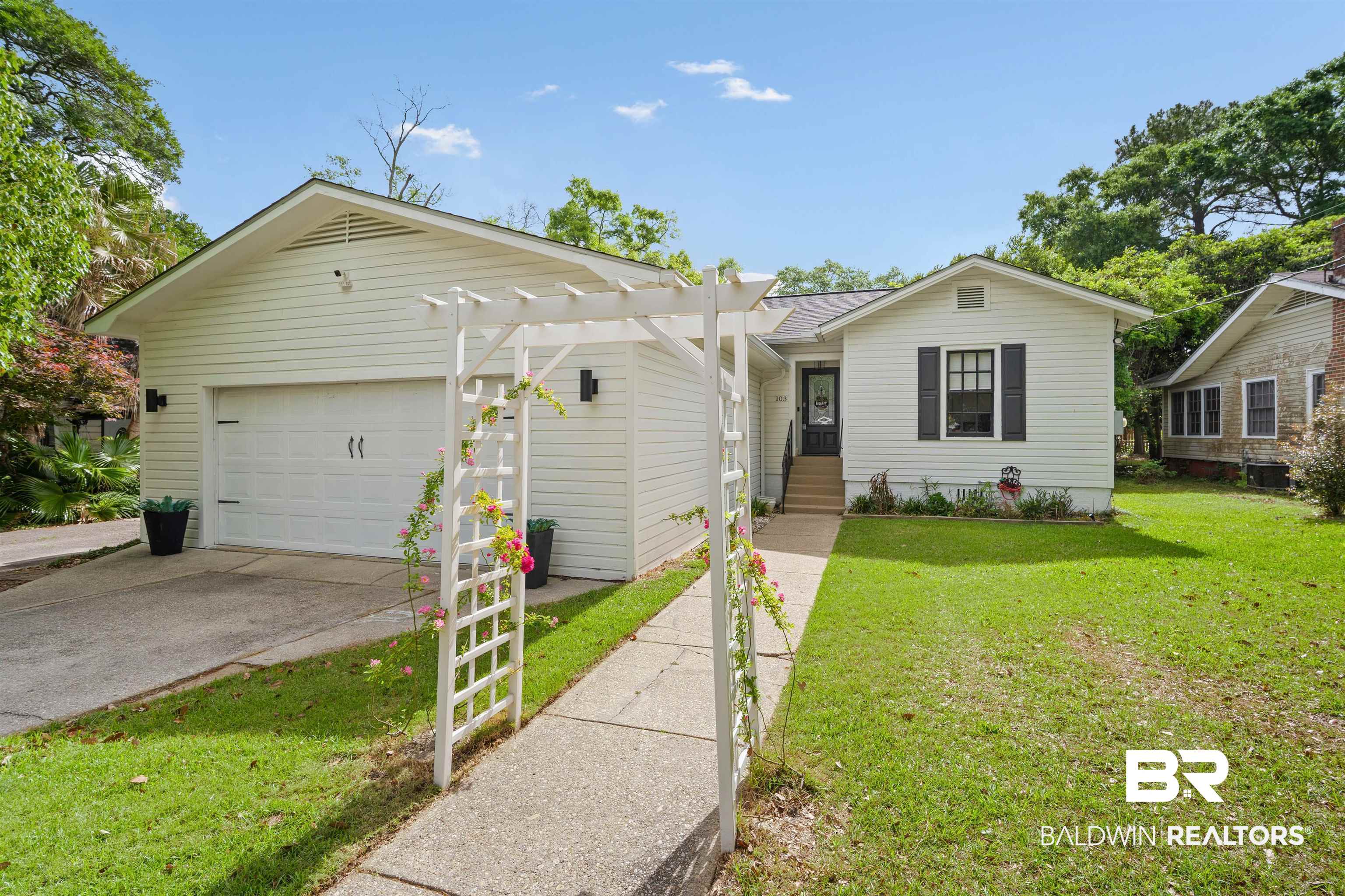 103 Emogene Place Mobile, AL 36606 - Photo 2 of 32 View of front facade featuring a front yard, a garage, concrete driveway, and a shingled roof