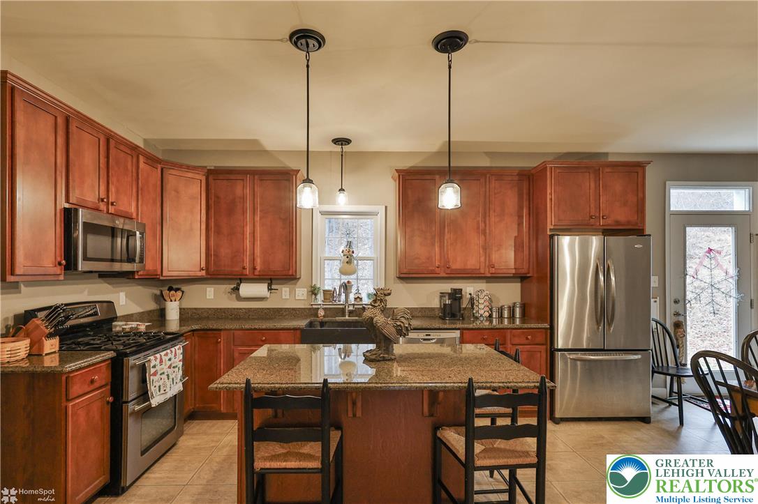 3475 Honeysuckle Road Bethlehem, PA 18015 - Photo 26 of 87 a kitchen with stainless steel appliances granite countertop a sink a stove a refrigerator cabinets and chairs