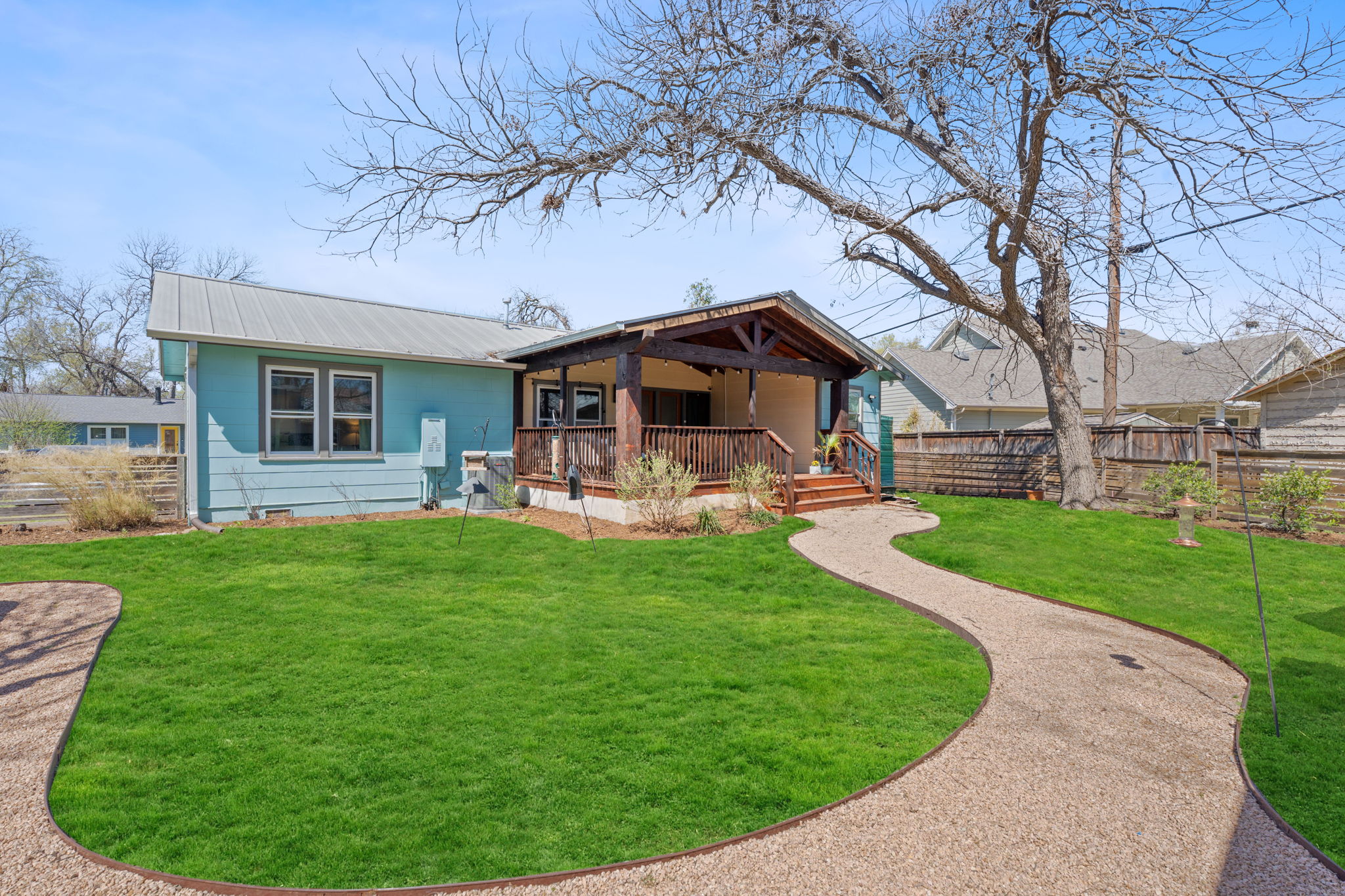 Back of property featuring a yard, fence, and metal roof