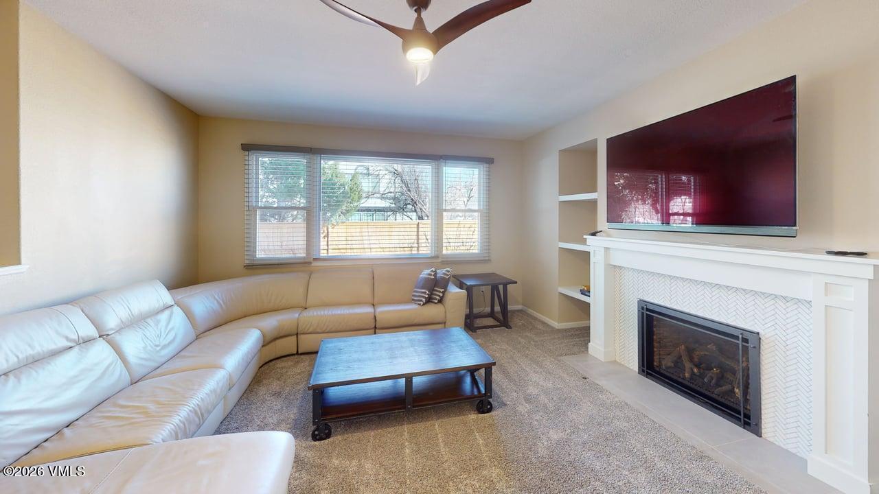 8958 South Forrest Drive Littleton, CO 80126 - Photo 19 of 27 a living room with furniture a flat screen tv and a fireplace