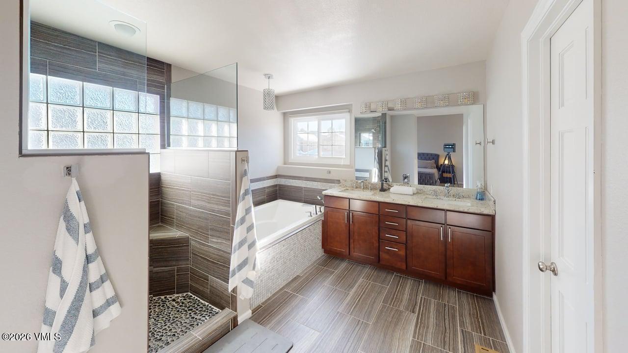 8958 South Forrest Drive Littleton, CO 80126 - Photo 5 of 27 a bathroom with a double vanity sink a mirror and a bathtub