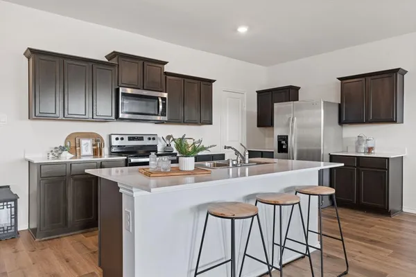 a kitchen with stainless steel appliances granite countertop a refrigerator stove microwave and sink