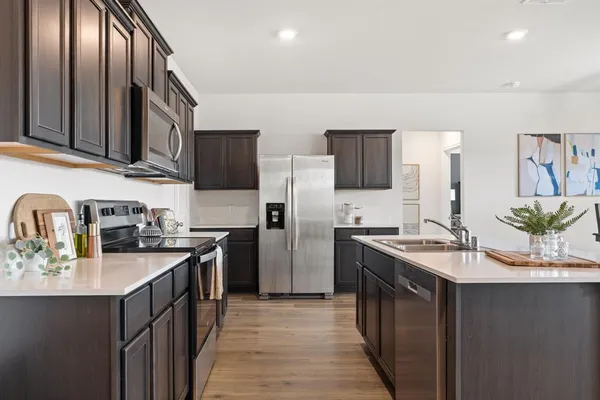 a kitchen with a sink stove top oven and refrigerator