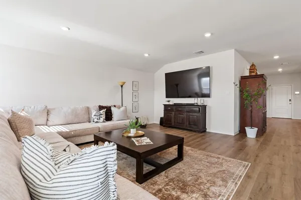 a living room with furniture and wooden floor