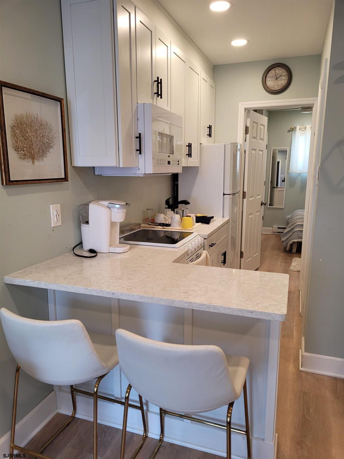 9401 Pacific Avenue, Unit 8 Margate City, NJ 08402 - Photo 4 of 8 a kitchen with stainless steel appliances granite countertop a sink a stove a refrigerator a microwave a counter top and cabinets