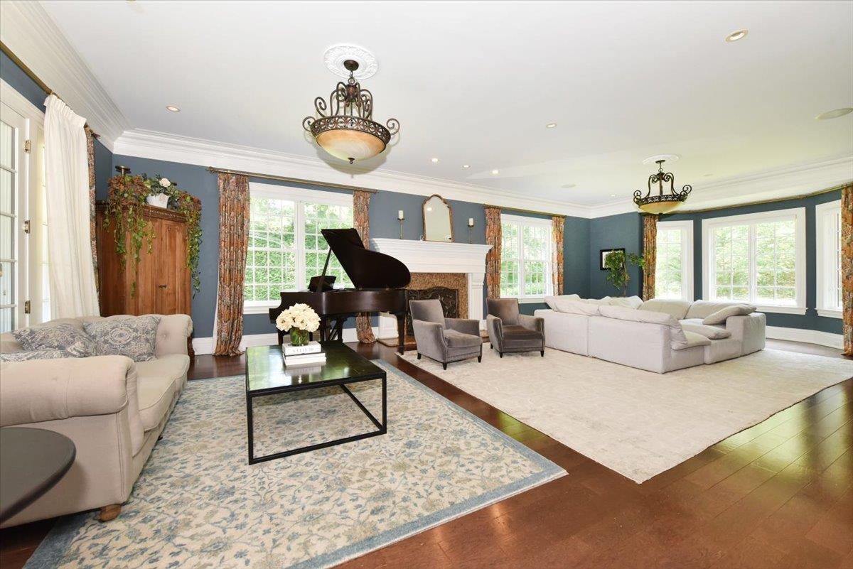 1616 Stewart Lane Syosset, NY 11791 - Photo 11 of 38 Living area with healthy amount of natural light, wood finished floors, crown molding, a high end fireplace, and recessed lighting
